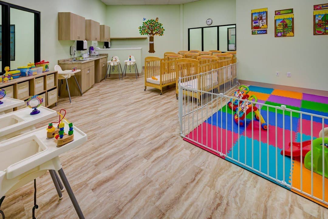 The infant room, with cribs and a soft play area